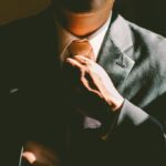 Hombre elegante acomodandose la corbata