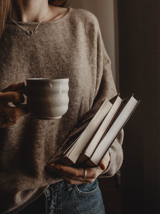 una joven tomando cafe preparandose para leer libros