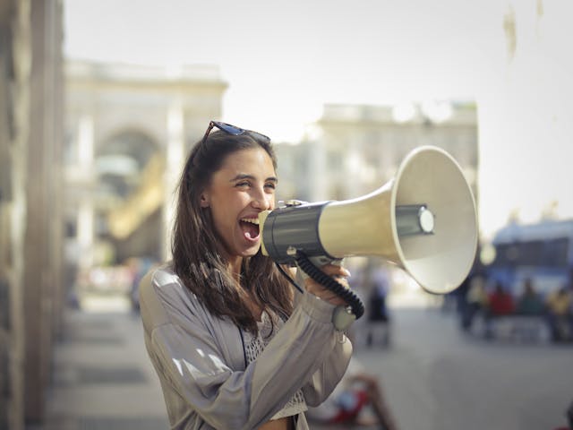 mujer con altavoz en el arco del triunfo
